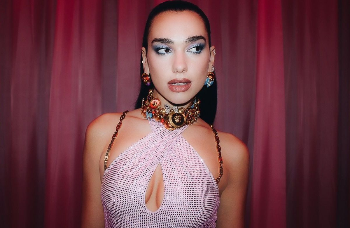 Dua Lipa poses next to a car wearing a micro bikini with gold chains