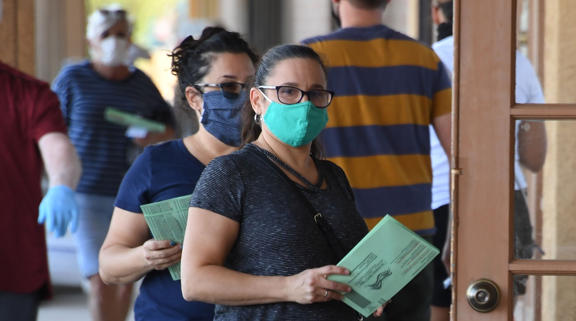 Men in balaclavas guard ballot boxes with guns and bulletproof vests during voting in Arizona