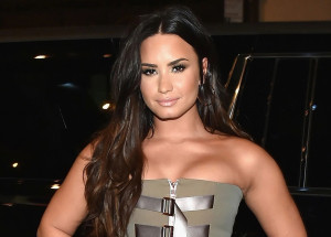 Wearing a black jumpsuit Demi Lovato takes a selfie in which she shows off her figure
